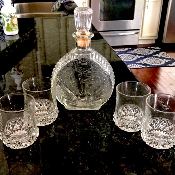 Bourbon bottle with four bourbon glass .